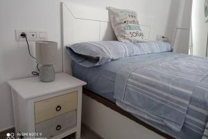 a small bedroom with a bed and a night stand at Precioso apartamento con terraza en Teguise in Teguise