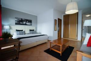 a bedroom with a large bed and a table at Oasis Beach Apartments in Luz