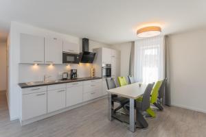 Ifta的住宿－Wohlfühlappartements „Natur & Flair“，厨房配有白色橱柜和桌椅
