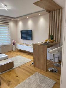 Una sala de estar con una mesa y un televisor en la pared. en Jellenaa, en Zlatibor