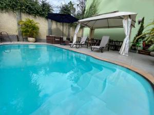 uma grande piscina com água azul em Princesa Isabel Pousada e Hotel – Dom Pedro em Petrópolis