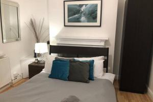 a bedroom with a bed with blue and white pillows at Le Grande Newport in Newport