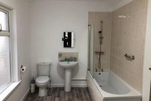 a bathroom with a toilet and a sink and a bath tub at Le Grande Newport in Newport