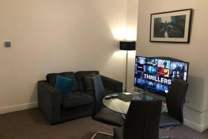 a living room with a couch and a television at Le Grande Newport in Newport