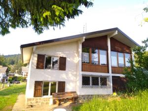 una casa con una panchina davanti di Pisolo Cottage a Ronzone