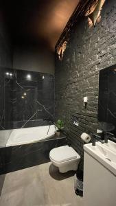 een badkamer met een wit toilet en een bad bij DarkHouse2 in Łódź