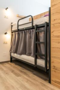 a bunk bed in a room with a wooden floor at Four Rooms Hostel in Lugo