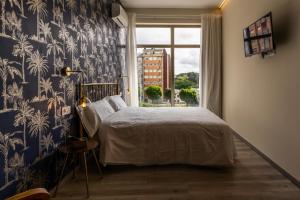a bedroom with a bed with blue and white wallpaper at Four Rooms Hostel in Lugo