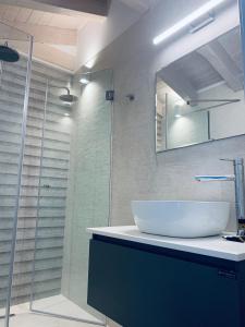 a bathroom with a sink and a glass shower at Terpsichore boutique Bright new Sofita studios and appartment in Dassia +29 photos
