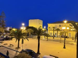 eine Stadtstraße mit Palmen und einem Gebäude in der Unterkunft Appartamento Suite Calipso in Pozzallo