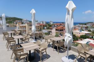 a patio with tables and chairs and umbrellas at Summer Point Hotel in Ksamil