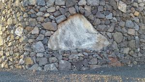 a large rock on the side of a stone wall at Casa da estrela sirius in Cabeço Chão