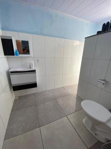 une salle de bains blanche avec toilettes et lavabo dans l'établissement Recanto da Lua, à Corumbau
