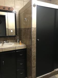 a bathroom with a shower with a sink and a mirror at Front beach private room with shared bathroom in Cancún +84 photos