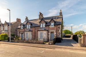 an old brick house on the side of a street at Luxury Inverness central apartment private parking in Inverness