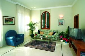 a living room with a couch and a tv at Villa Helvetia in Grottammare
