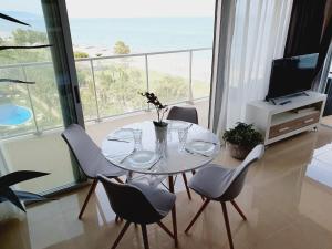 uma sala de jantar com uma mesa e cadeiras com vista para o oceano em Holiday Deluxe Apartment Miramar Marina d'or em Oropesa del Mar