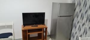 una televisione su un tavolo accanto a un frigorifero di Jajo a Brindisi