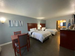 Habitación de hotel con 2 camas y escritorio en Quarters Inn & Suites, en Antioch