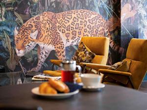 a table with a leopard painting on a wall at Queens Hotel & Spa Bournemouth in Bournemouth