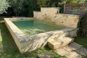 una gran piscina de agua en una pared de piedra en Chez Lydia - Rivière, Pont-du-Gard accès à pied !, en Castillon-du-Gard