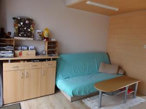 Apartment De Paprente في Merkem: أريكة في غرفة مع طاولة وكرسي