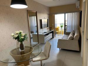 a living room with a glass table and a couch at Apto Top Custo-Benefício Qualidade e preço que surpreendem in Maceió