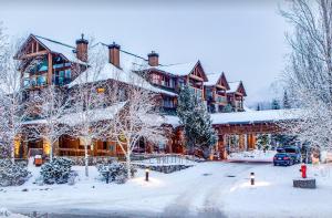 a lodge in the snow with snow covered trees at Beautiful 2 bedroom overlooking Whistler's Green Lake and Mountains! in Whistler