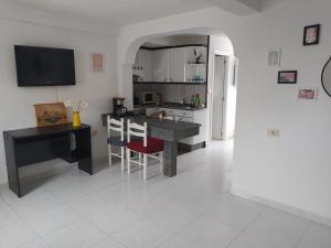 a kitchen with a table and a desk and a counter at Apartamento en primera línea de playa in Laxe