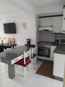 a kitchen with a table with a red chair in it at Apartamento en primera línea de playa in Laxe