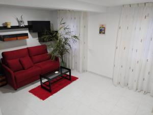 sala de estar con sofá rojo y mesa en Apartamento en primera línea de playa, en Laxe