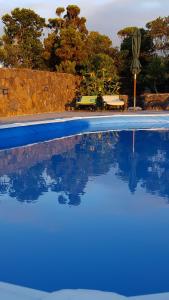 a swimming pool with blue water and a table and chairs at Casa da estrela canopus in Cabeço Chão