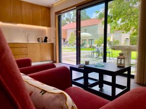 a living room with a red couch and a table at Casa do Pomar - Eido do Pomar in Arcos de Valdevez