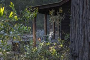 einem Picknicktisch auf einer Veranda einer Hütte in der Unterkunft Kianinny Bush Cottages in Tathra