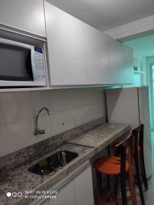 Kuchyň nebo kuchyňský kout v ubytování Confortável Flat com piscina de borda infinita na cobertura