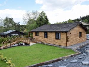 a log home with a large yard and a deck at Cosy chalet in Durbuy in a beautiful hiking area in Durbuy
