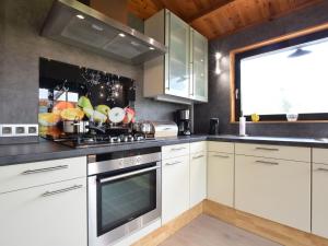 a kitchen with white cabinets and a sink at Cosy chalet in Durbuy in a beautiful hiking area in Durbuy