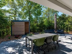 a patio with a wooden table and chairs at Villa in Texel near Beach and Nature Reserve in Den Burg