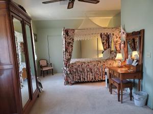 a bedroom with a bed and a desk with a desk at American River Inn in Georgetown