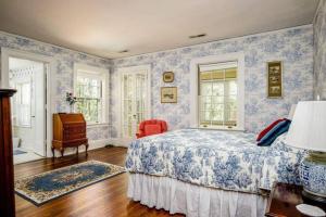 ein Schlafzimmer mit blauen und weißen Tapeten und einem Bett in der Unterkunft Knollwood Manor - The Historic Mid Pines Mansion in Southern Pines