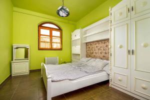 バラトンマーリアフュルドゥーにあるApartments in Balatonmariafürdo/Balaton 19491の緑の壁のベッドルーム(白いベッド付)