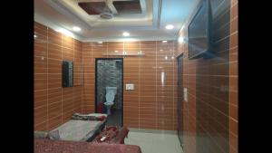 a bathroom with brown tiled walls and a toilet at Room in Guest room - Posh Foreigner Place Luxury Room In Lajpat Nagar in New Delhi