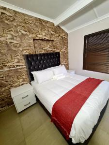 a bedroom with a large bed and a stone wall at 36 frere road shelly beach , margate in Margate