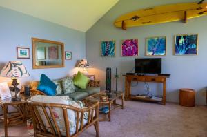 a living room with a couch and a tv at Sealodge J9 in Princeville