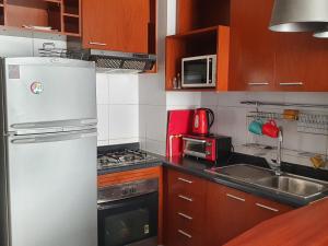 a kitchen with a white refrigerator and a sink at DEPTO 714 EXCELENTE UBICACION Metro, Barrio Paris Londres CENTRO SANTIAGO in Santiago