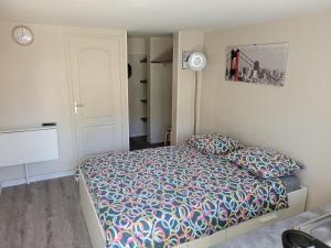a bedroom with a bed with a colorful comforter at Studio Buffon in Mitry-Mory