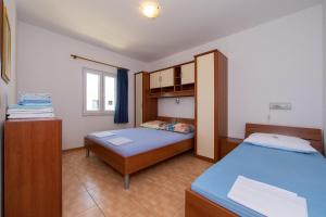 a small bedroom with two beds and a window at Apartments Ruzica - sea view in Igrane