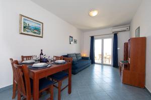 a dining room with a table and a couch at Apartments Ruzica - sea view in Igrane