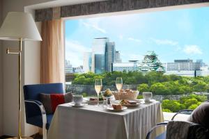 een tafel met wijnglazen en uitzicht op de stad bij Hotel New Otani Osaka in Osaka