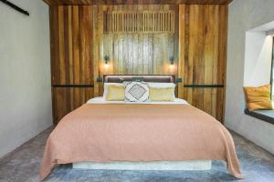 a bed with a white bedspread and pillows at Surfing Temple Hotel Boutique in General Luna